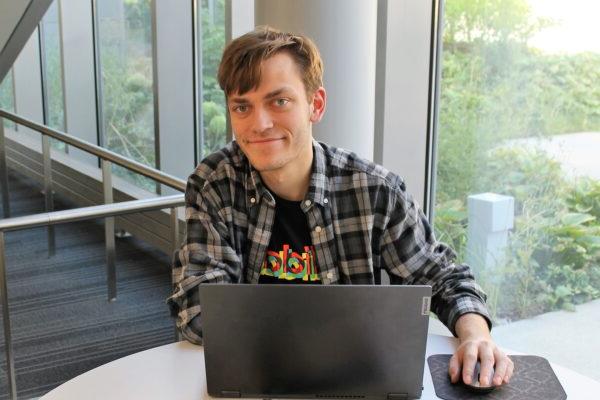 a person sitting at a table with a laptop